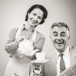 Grayscale image of a smiling 1950s couple with the woman pouring tea into the man's cup